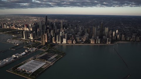 Chicago, Illinois - Circa-2015: High altitude wide angle aerial view flying over Lake Michigan looking toward the downtown core city skyline with the sunrise reflecting off of buildings