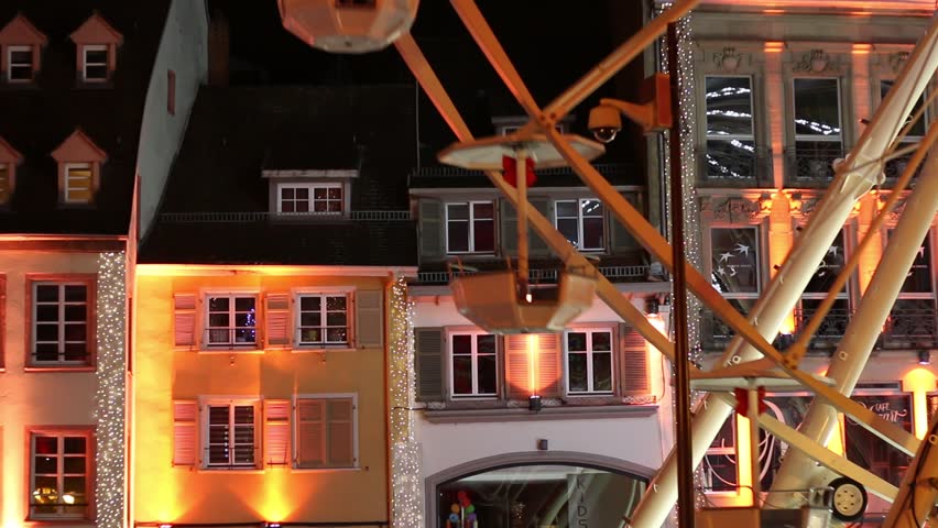 Big wheel in front of a wall with lights. By night at cristmas market, Mulhouse, Alsace