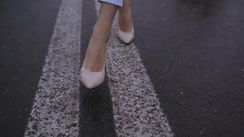 girl goes along the dividing strip on the way in an empty city