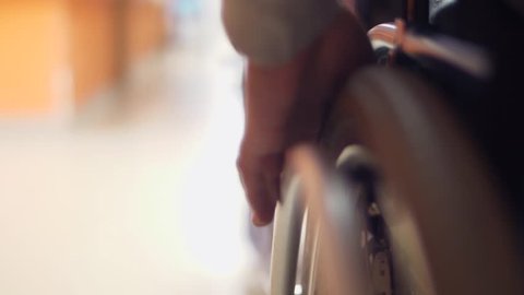 disabled man safely drives wheelchair in corridor institution slow motion