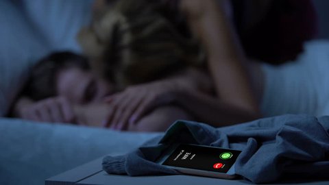 Wife incoming call, husband sleeping on bed after night with mistress, betrayal