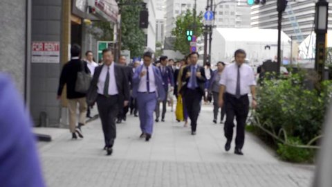 Tokyo, Japan - September 25, 2018: Men in business suits walking along the street in Tokyo,Japan