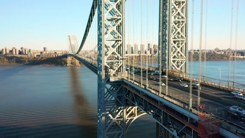 Aerial drone footage of George Washington Bridge with view along Hudson River, towards New York City (upward movement)