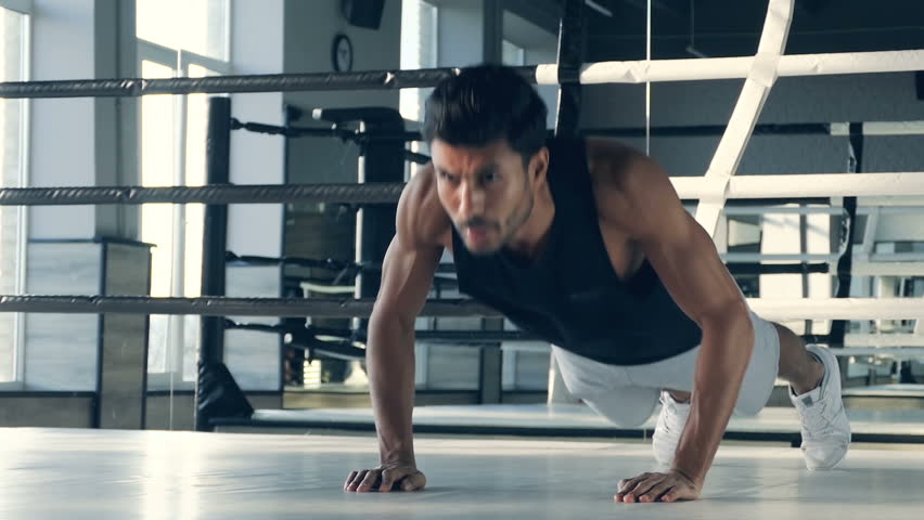 Boxer doing push up excercise at the boxing ring.