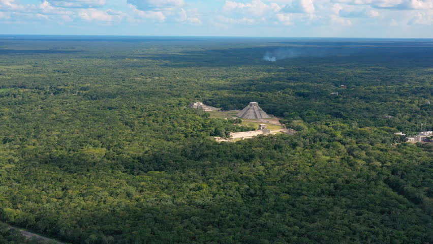 Aerial view of ancient Mayan city of Chichen Itza, famous mesoamerican pyramid El Castillo (Temple of Kukulkan) - landscape panorama of Yucatan Peninsula from above, Mexico, North America, 4k UHD