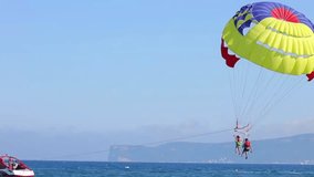 To ride a parachute it is high over the sea. Entertainment on a resort beach
