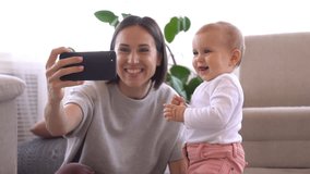 Mother taking selfie with baby girl using mobile phone