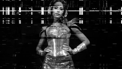 amazing woman dances in a sparkling silver costume with silver shiny body piece, with intentional overlayed video distortion and glitch effects.