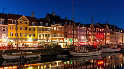 COPENHAGEN, DENMARK - CIRCA 2018: Nyhavn canal at night, Copenhagen city center. Colorful facades, city lights and water reflection. Time lapse video.