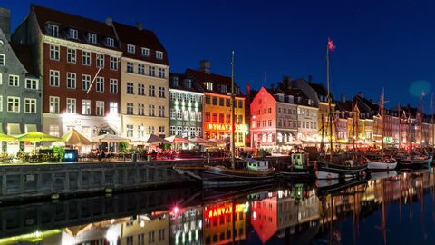 COPENHAGEN, DENMARK - CIRCA 2018: Nyhavn canal at night, Copenhagen city center. Colorful facades, city lights and water reflection.