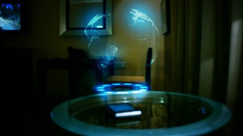 Globe Hologram projection in a dark room. Futuristic Device on a table. Concept: New technologies, Connection, Network, Mobile Technology, Hud, Sci fi