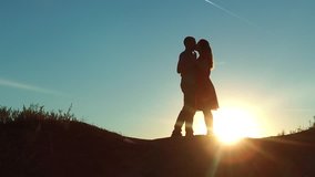 couple at sunset silhouette kiss hugging. slow motion video. young couple kissing at sunset. man and girl meet each other silhouette. romance love concept lifestyle video