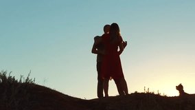 silhouette of a happy young married couple and dog slow dancing outside at sunset. slow motion video. man and girl dancing salsa at sunset. Unidentifiable Silhouette of dancing couple lifestyle love