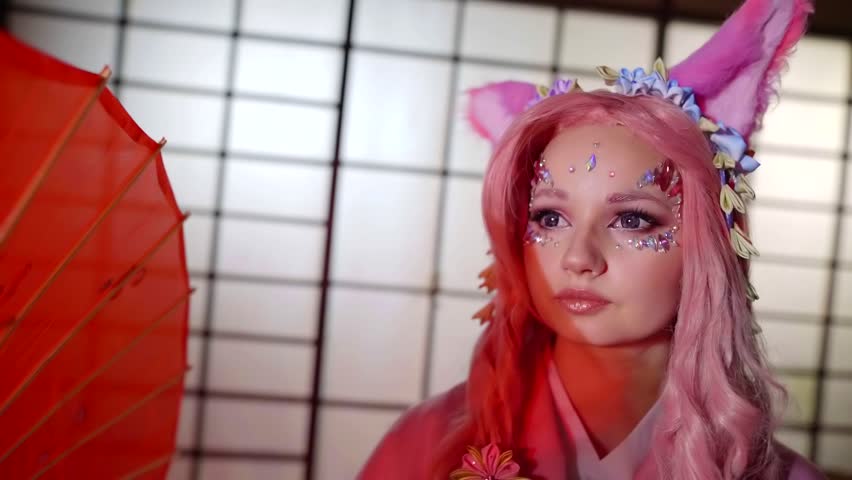Anime model with pink hair wearing pink kimono posing with red umbrella in washitsu.