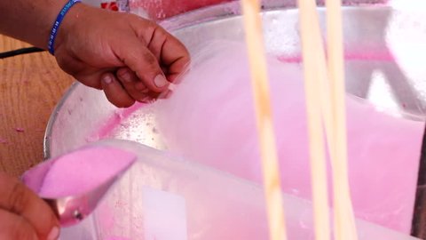 Vendor using pink cotton candy machine in local fair. Industrial machinery, sweet food stall, party, event holiday, market concepts