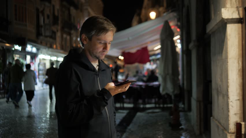 Man voice recognition with smart phone in park night hotel outdoor, student male use message audio helper finder ai young freelancer tourist on street find route home