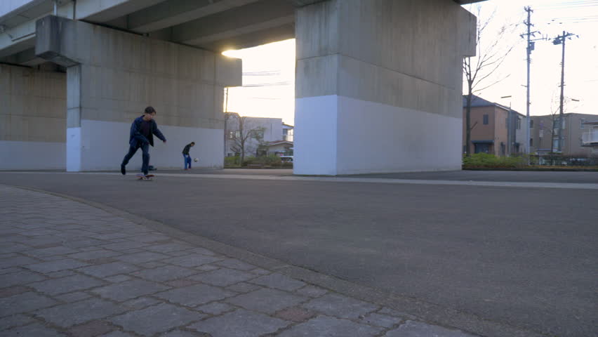 Young Japanese man riding his skateboard in urban Japan.