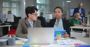 Young asian and afro-american web designers discussing the project with the customer having video conference on laptop computer