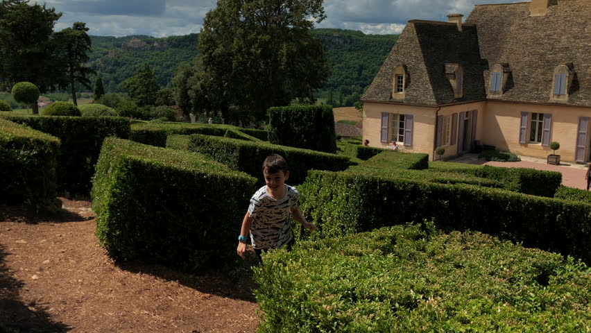 Young children playing hide and seek in a beautiful old maze 