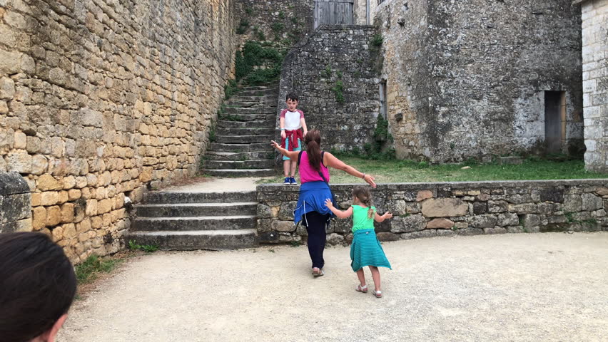 Mother playing with her children twirling them in her arms