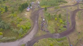 Top view of off-road racing with SUVs. Clip. View of finishing SUV racing in forest against crowds of fans