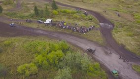 Top view of SUVs driving on country road. Clip. Off-road racing on mud roads in rural forest area
