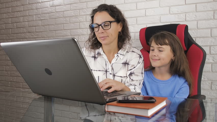 Work at home. Mother with a child at the computer. Surprise of the child from the Internet.