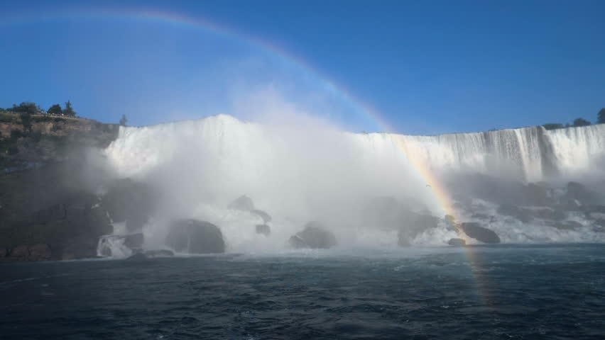 Giant rainbow over the beautiful and impressive panorama of the Niagara Falls in Ontario (Canada).