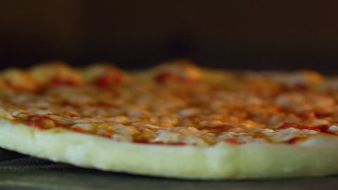 Italian Pizzaiolo Pizza Maker Put Into The Oven Pizza In The Kitchen Of The Restaurant.