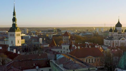 Reverse aerial over Tallinn old town opening onto Toompea hill. Passing over Estonian Government building
