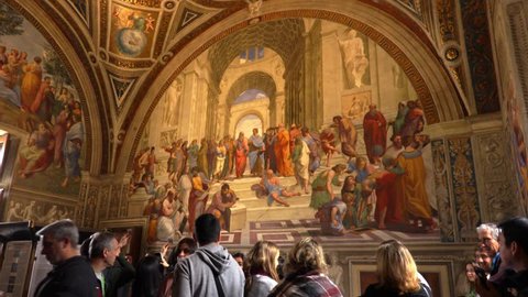 Rome, Italy - 02.01.2018: A woman takes a photo of the frescoes of the Italian Renaissance artist Raphael inside the Vatican Museum. It is called The School of Athens (Italian: Scuola di Atene) 
