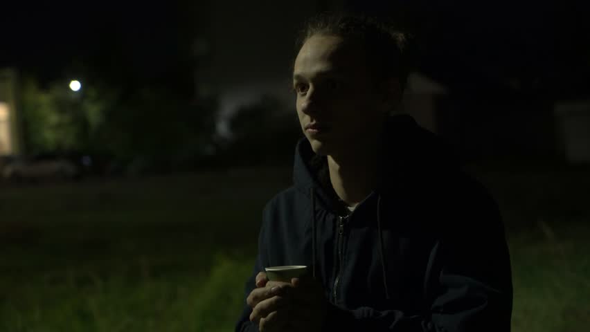 frozen man drinking hot coffee on the streeet at night, 4k footage