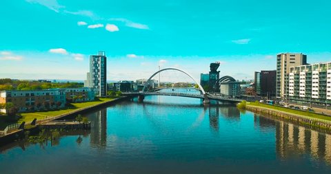 Drone shot of the River Clyde, jibs up to reveal the Clyde Arc (Squinty Bridge) & the cityscape of Glasgow. 