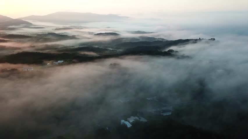 Surreal sunrise in the Smoky mountain skies. Drone video lifting up and panning to reveal the sunrise through the clouds in the Blue Ridge Great Smoky Mountains of Tennessee