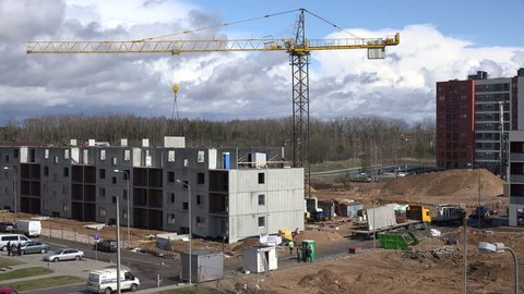 VILNIUS, LITHUANIA - APRIL 17, 2015: Construction site with crane and workers building new modern flat apartment house on April 17, 2015 in Vilnius, Lithuania. 4K UHD video clip.