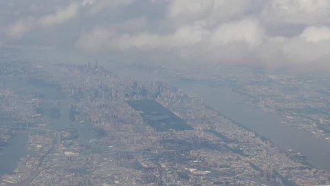 Manhattan and Central Park through a scrim of clouds out an airplane window during final descent
