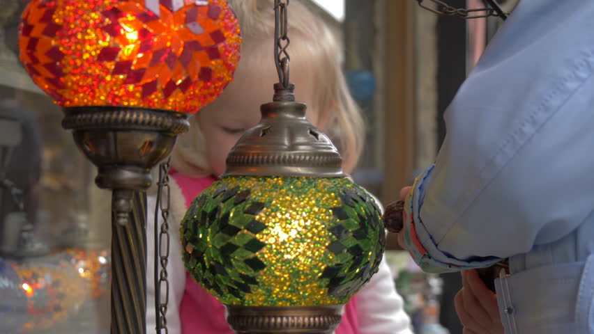 Two little girls are considering the amazing beauty of the lamps in the store in Istanbul.