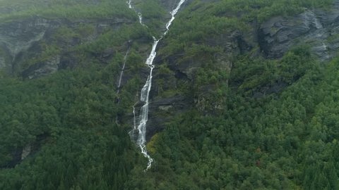 Waterfall on majestic rocky mountain aerial shot