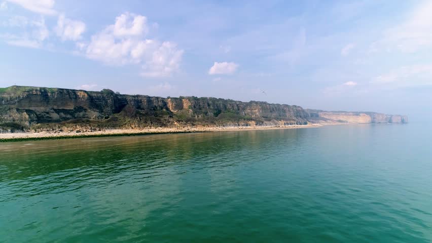 Drone footage - reverse aerial shot of cliffs at Omaha Beach (D-day World War 2) in Normandy France