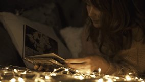 A young mother watch a family photo album at home on the couch. Christmas Holidays - Powered by Shutterstock - Get 15% off with code: PIKWIZARD15
