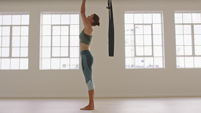 aerial yoga woman practicing flying splits pose using hammock hanging upside down enjoying healthy fitness lifestyle exercising in studio training meditation at sunrise