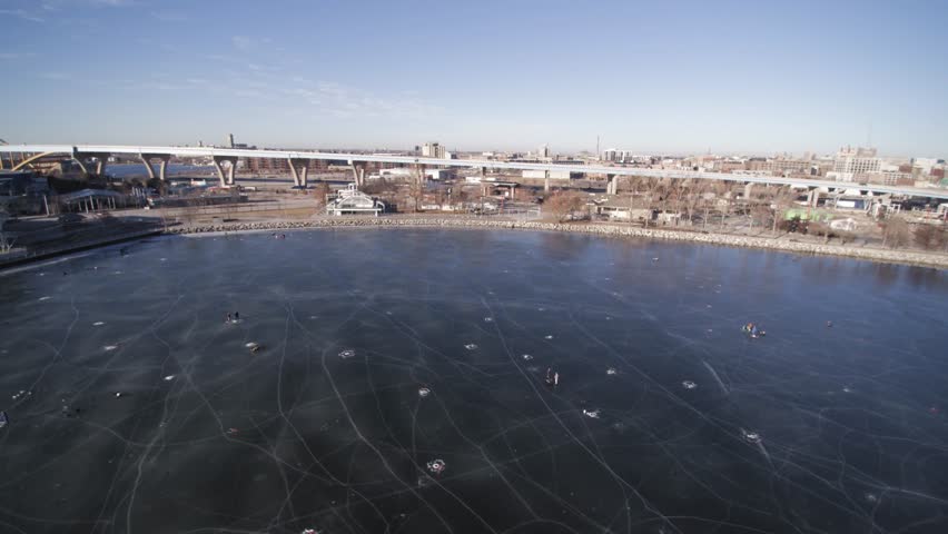 Direct overhead view of people ice fishing on a frozen lakeshore state park inlet lake.