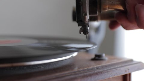 Record player or antique gramophone placing the needle on the record closeup.