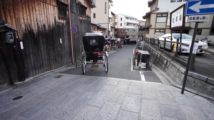 A traditional japanese Rickshaw takes a passenger to their destination in Kyoto, Japan.
