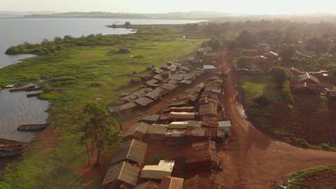 Aerial shot of a fishing village slum on the edge of lake Victoria Africa in the golden glow of sunset.