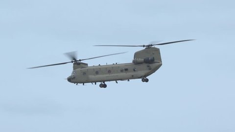 oslo airport norway - ca october 2018: military us army chinook boeing ch47 helicopter flying departure side view blue sky panning left