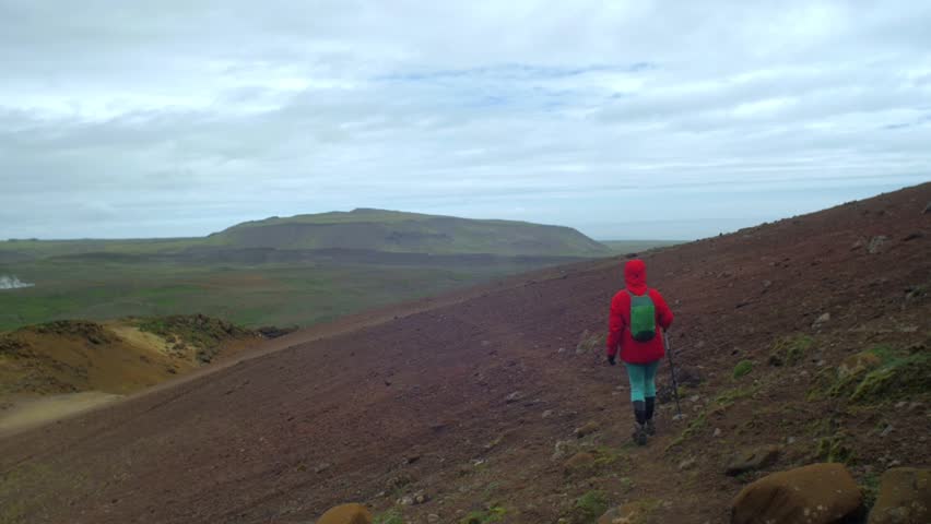 dramatic iceland landscape, person hiking on trail, krysuvik seltun area, camera following movmement, camera tracking - dolly in on a steadicam gimbal stabiliser