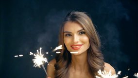 Party, drinks, holidays and celebration concept. Closeup of a woman dancing with sparklers in hands, toned video