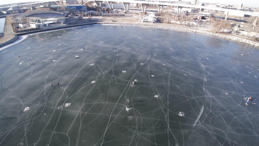 Aerial view of people ice fishing on a frozen park lake Michigan Milwaukee.
