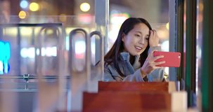 Tourist Woman take photo with cellphone on tram in Hong Kong at night
